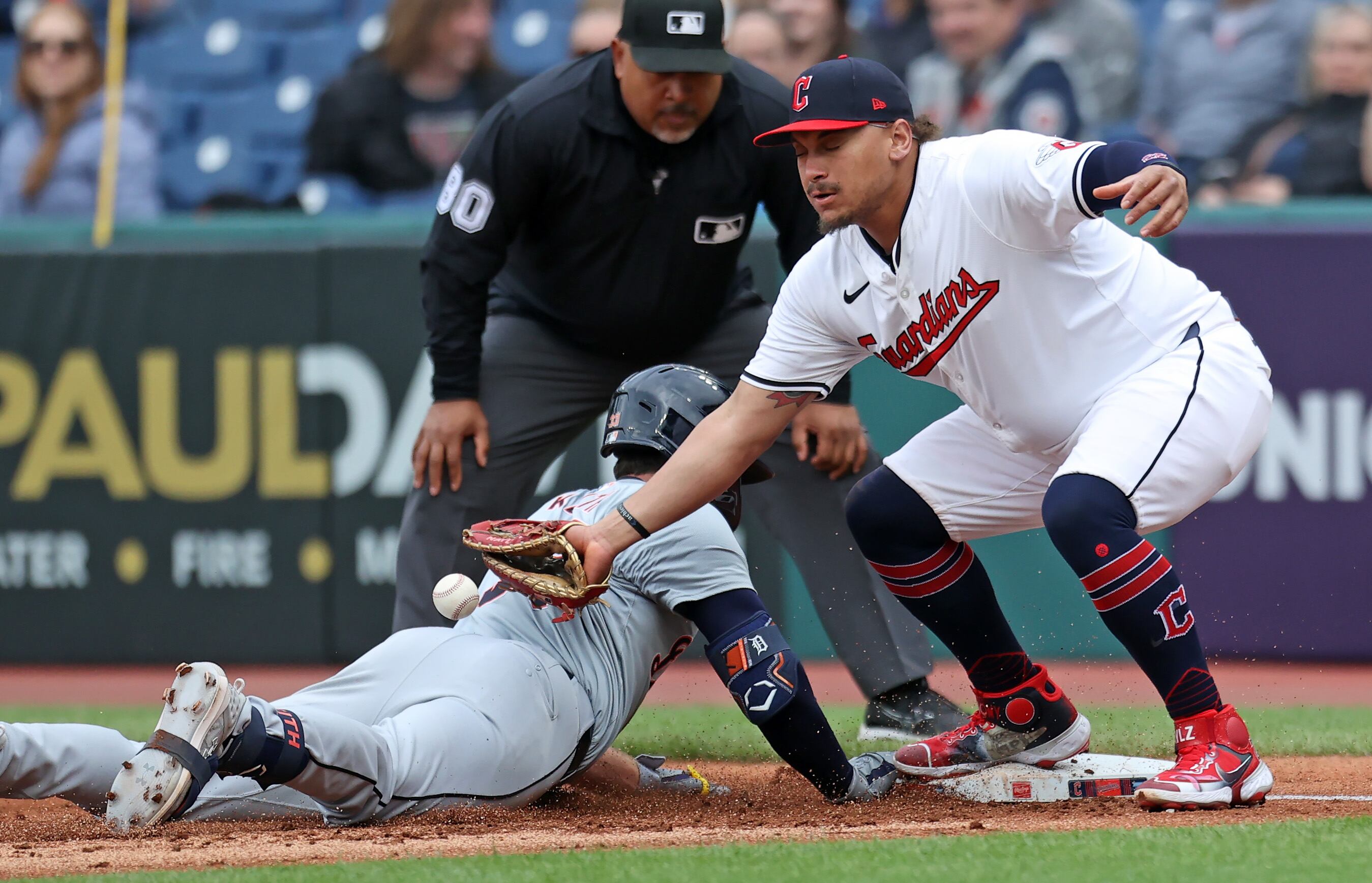 Detroit Tigers second base Colt Keith slides safe at first after starting toward second and returning as Cleveland Guardians first base Josh Naylor goes for the ball in the second inning. 