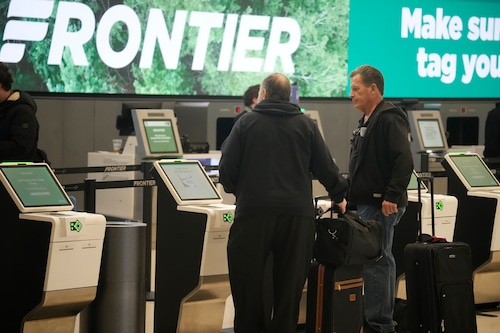Travelers check in at the self-service ticketing kiosks for Frontier Airlines in Denver International Airport on Monday, Nov. 20, 2023, in Denver.